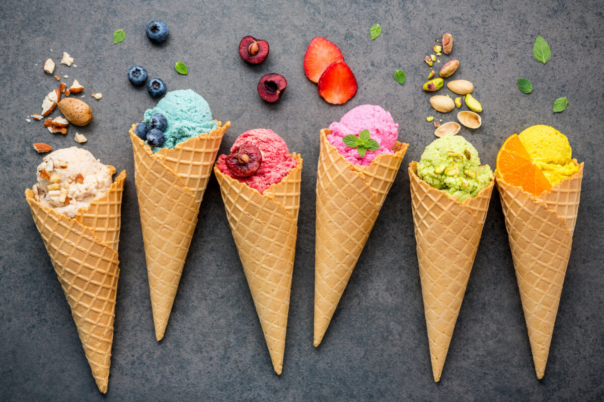 Six waffle cones with scoops of fruit flavoured ice cream