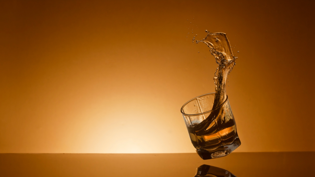 Glass of whisky splashing